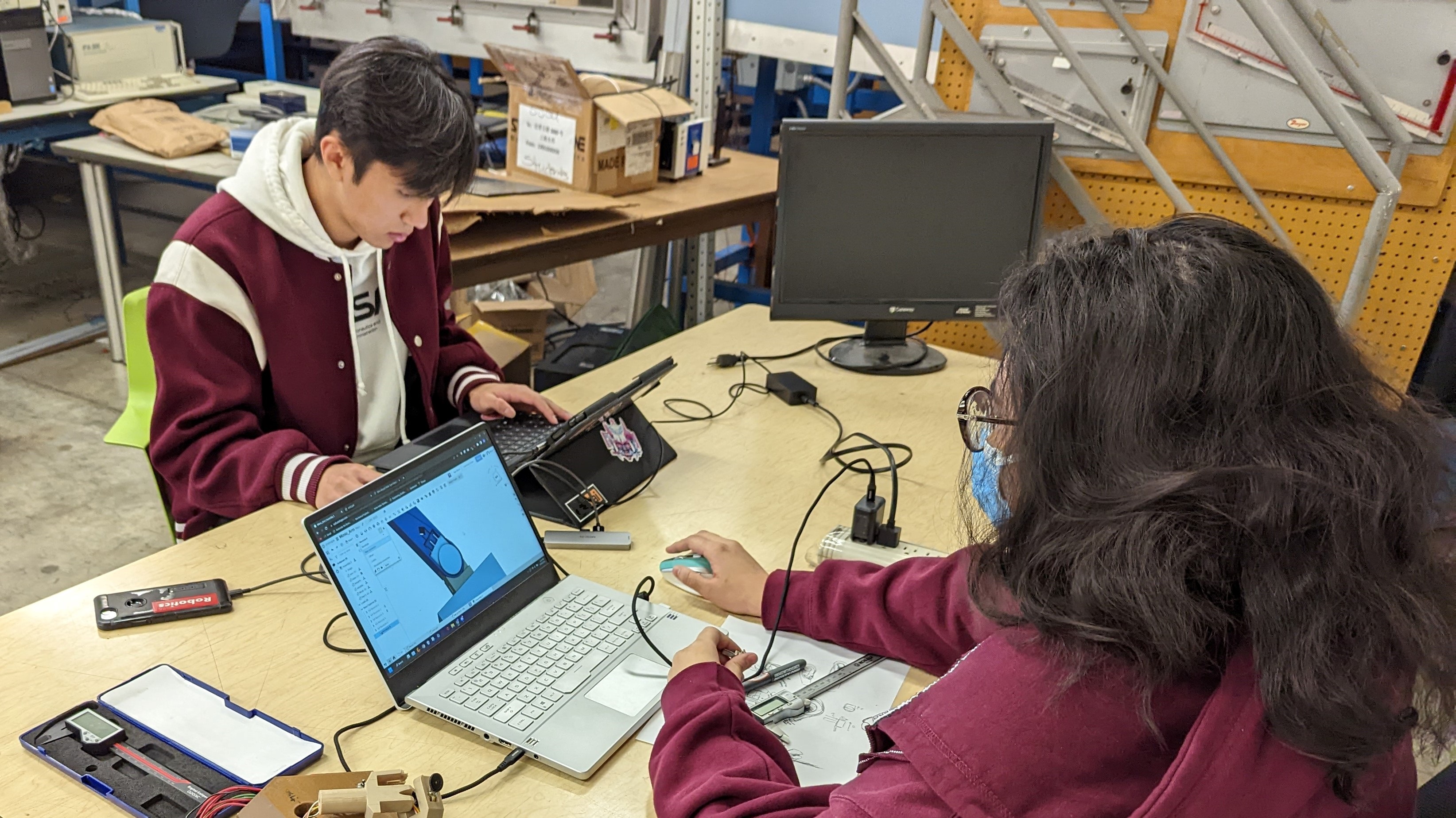 Robotics members around robotic arm